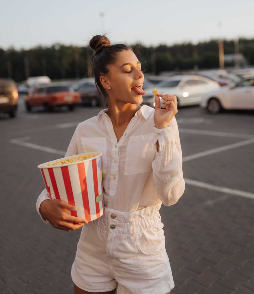 Chica en un cine de verano en Madrid comiendo palomitas