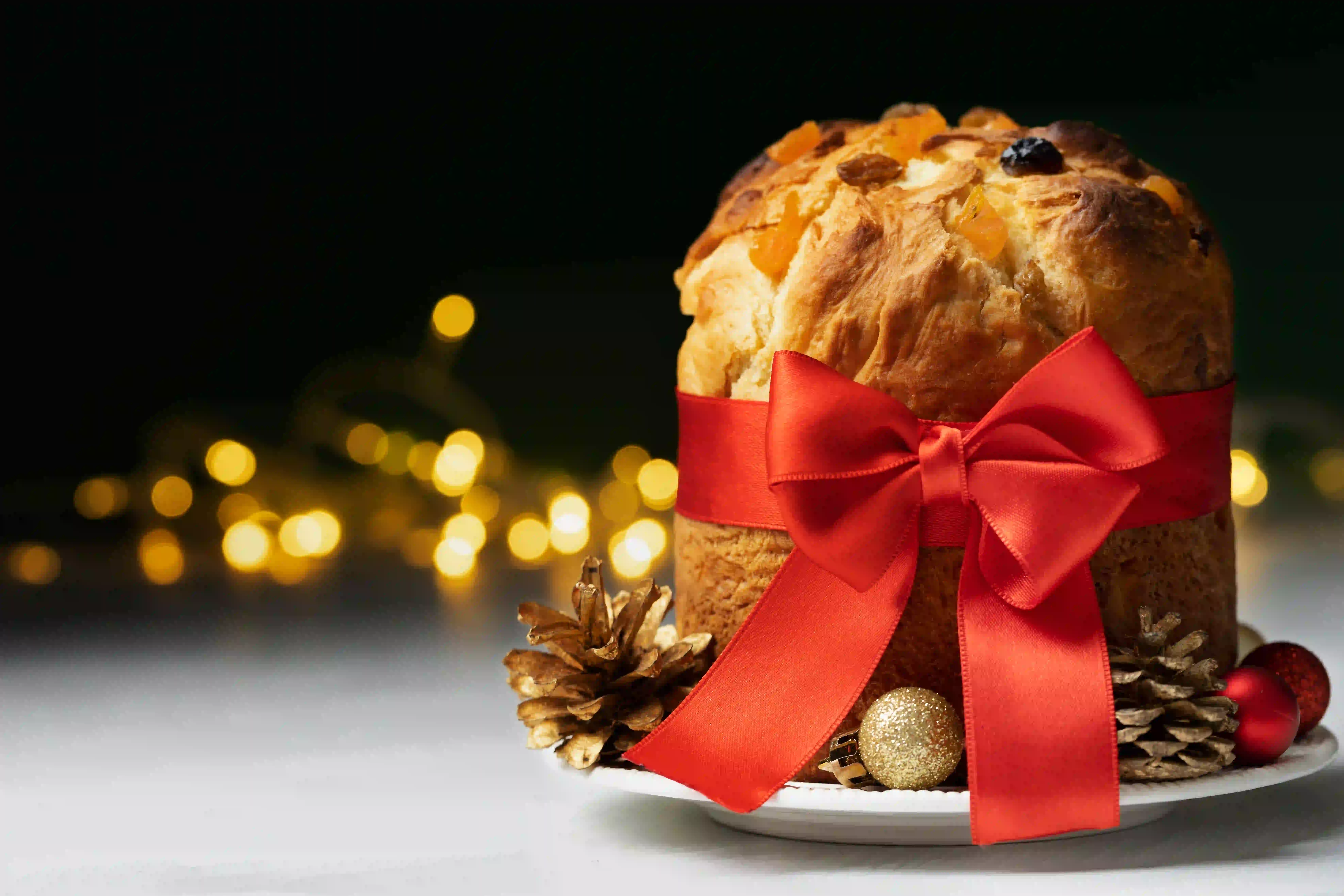 Panettone wrapped with a red Christmas ribbon