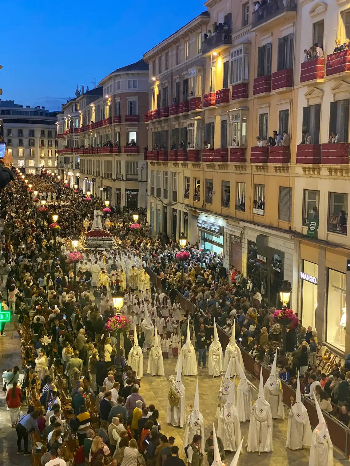 Procession with Nazarenes and throne among a crowd