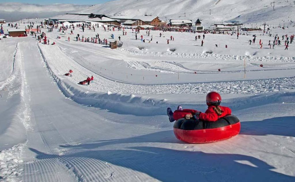 Niño deslizándose en un tub en Sierra Nevada