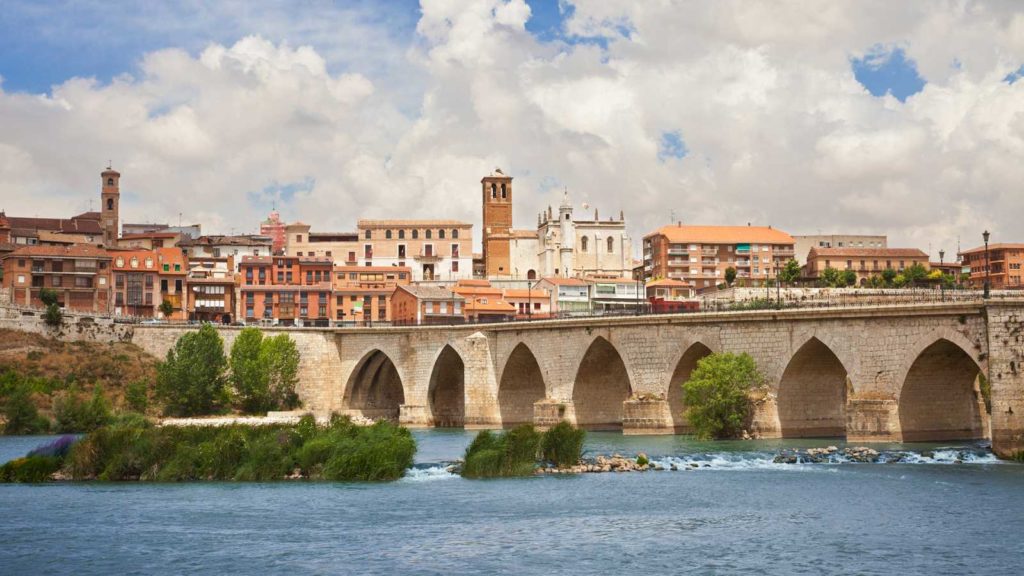 puente sobre río con ciudad de fondo
