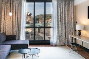 Vincci Consulado Bilbao, zona de espacio de trabajo con sofá, mesilla, mesa y ventana con vistas