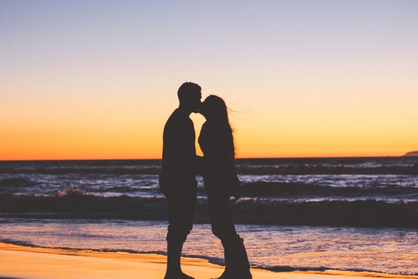 pareja dándose un en la playa al atardecer